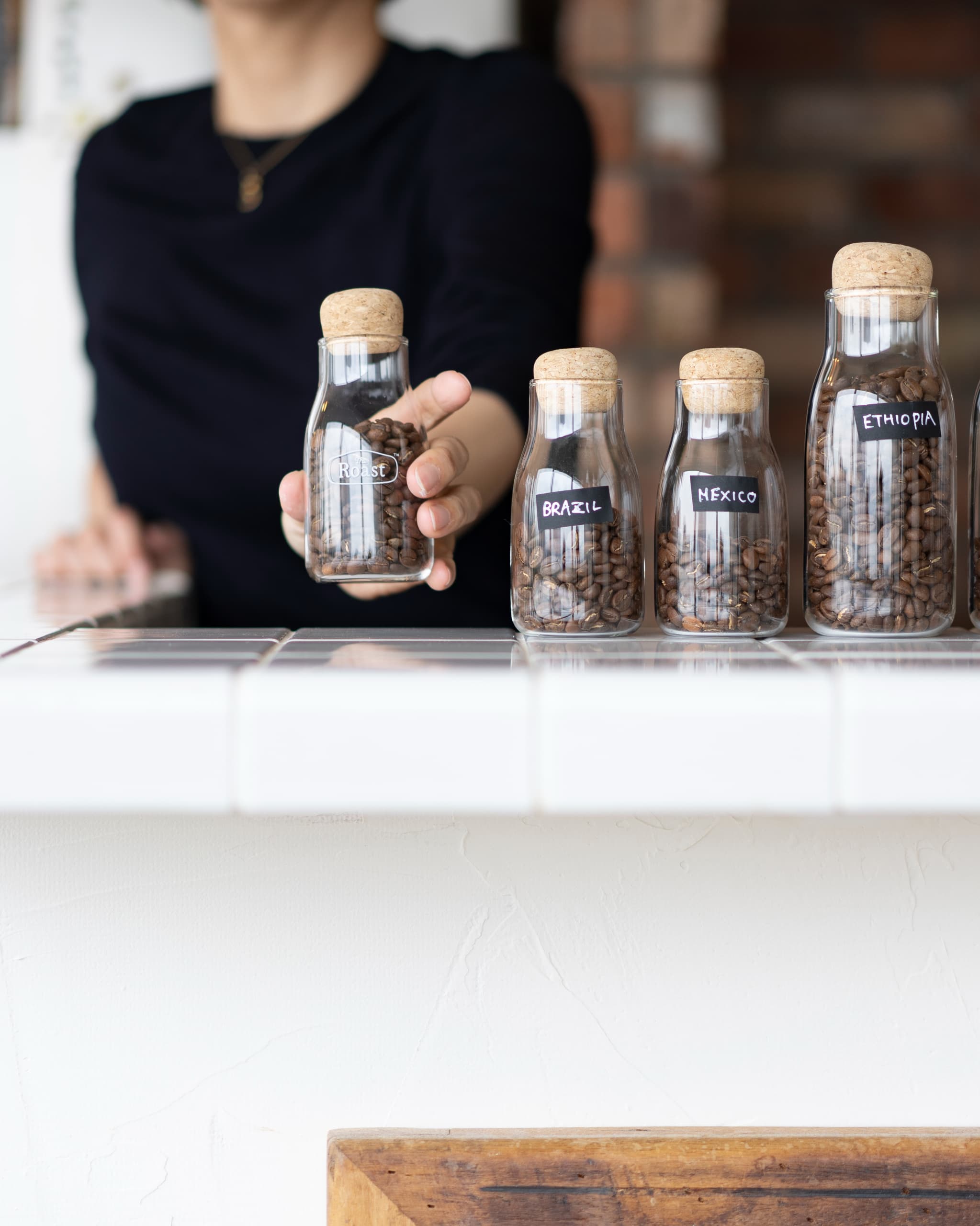 原産地がラベル付けされたコルク蓋付きガラス瓶に保存されたコーヒー豆。